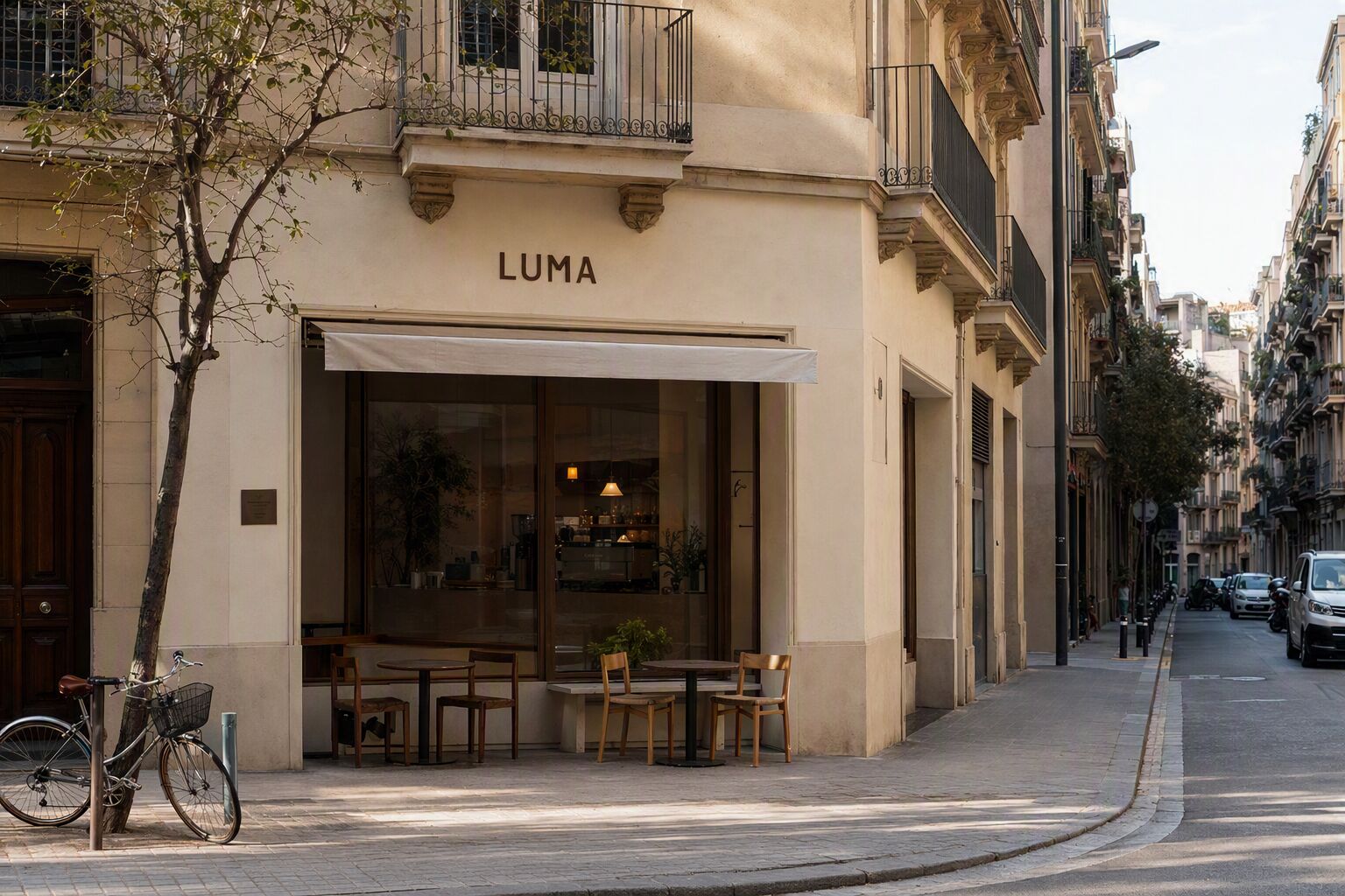 LUMA Coffee storefront on a quiet Eixample street in Barcelona, with outdoor seating and a bicycle parked outside
